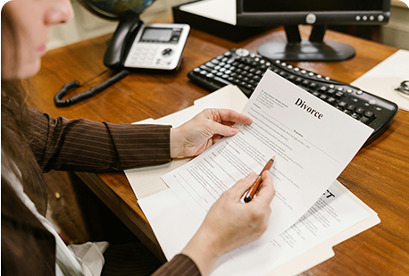 A person is writing on paper at the desk.